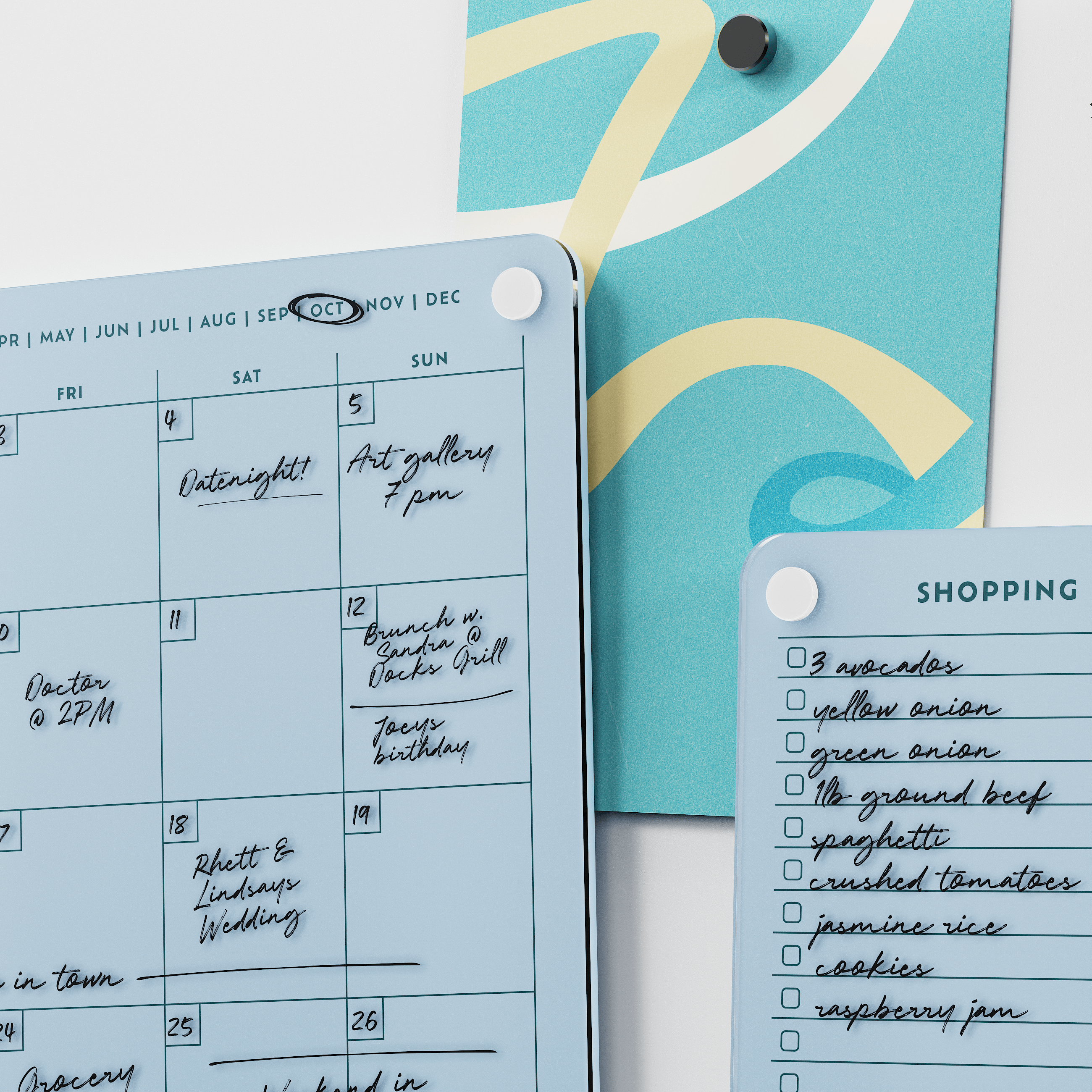 Close-up of the Vista blue monthly calendar and shopping list boards with handwritten plans and groceries